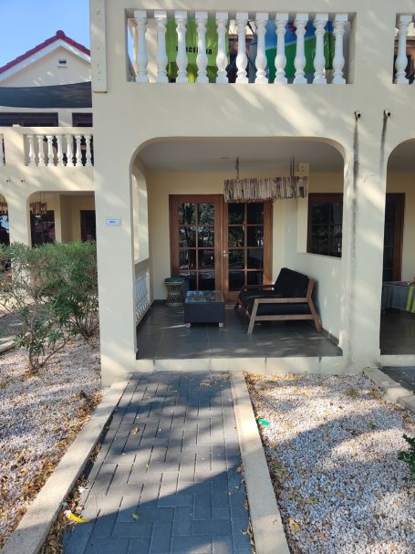 Terras met een zithoek en uitzicht op een tuin, omringd door stenen paden.
