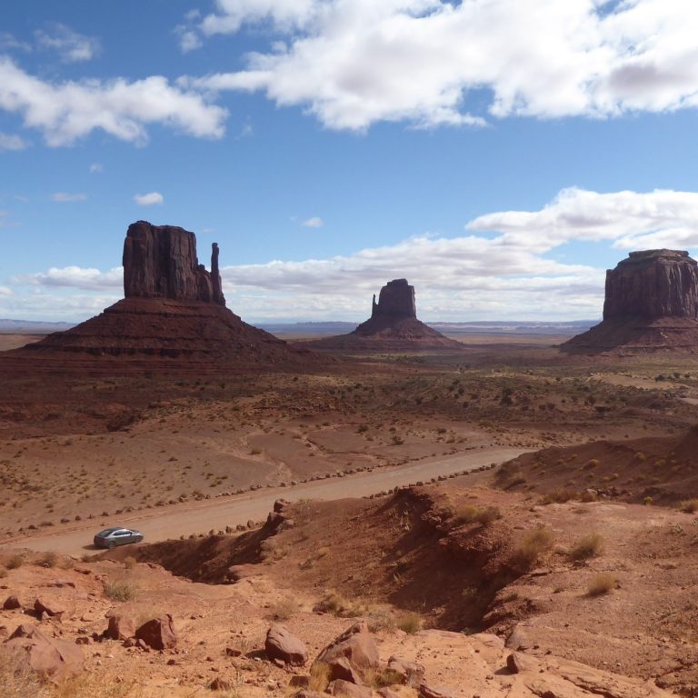 Uitzicht op rotsformaties in Monument Valley met een heldere blauwe lucht.