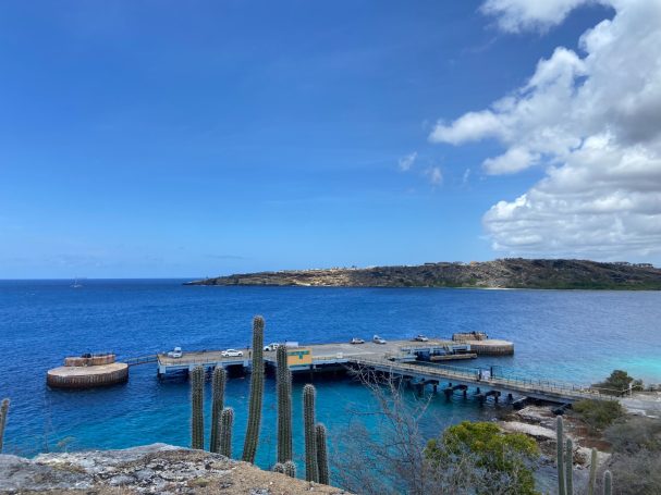 Een prachtig uitzicht op een pier bij turquoise water en een heldere blauwe lucht.